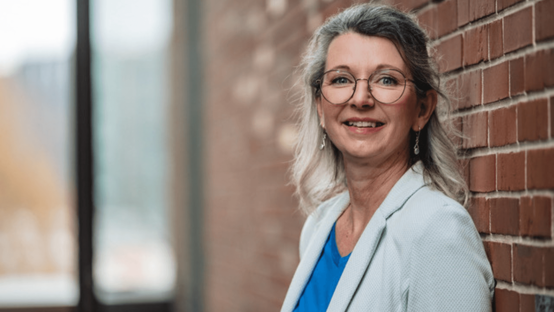 Heike Quendt, Architektin der Zell-Energie, vor der historischen Ziegelwand des Josephs Hofs – Fokus auf Souveränität und Herzenskraft.